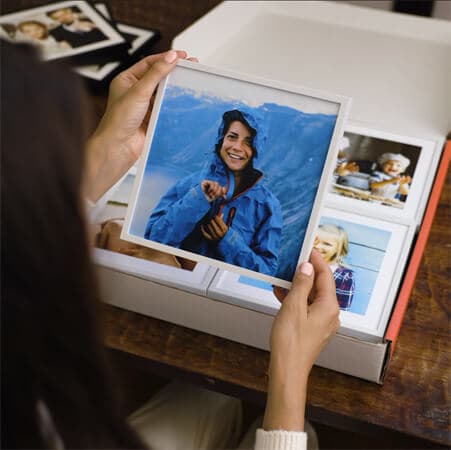 A woman presents a white frame photo tile
