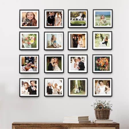 A gallery wall of sixteen stickable photo tiles with black frames.