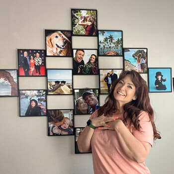 A happy mom next to her photo tiles wall.  