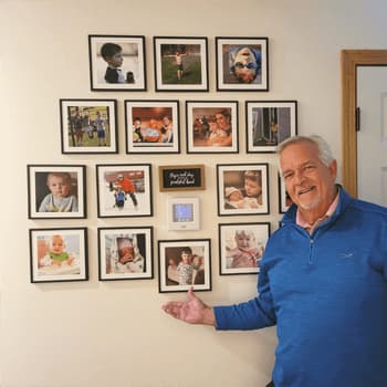 Grandfather presents a photo gallery wall of his grandchildren.