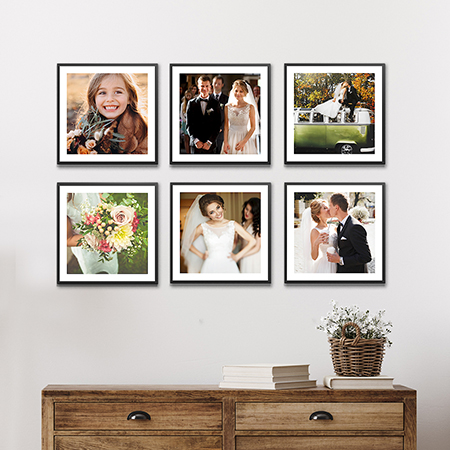 A gallery wall of sixteen stickable photo tiles with black frames.